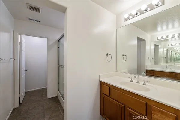 a bathroom with a granite countertop sink a mirror and a shower