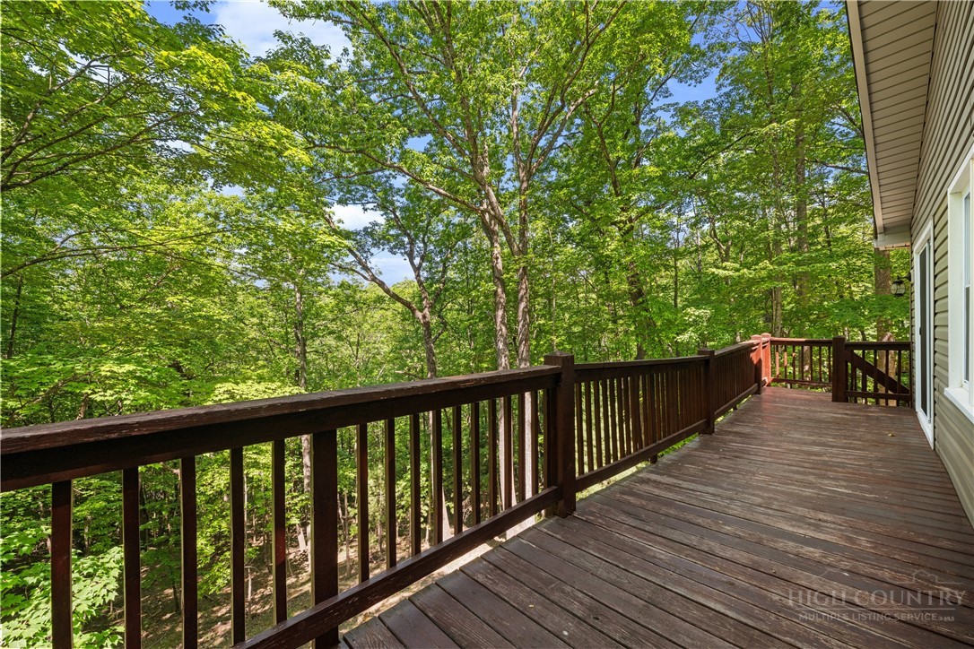 467 Horseshoe Ridge Road East Deep Gap, NC 28618 - Photo 5 of 46 a balcony with wooden floor and trees in the back