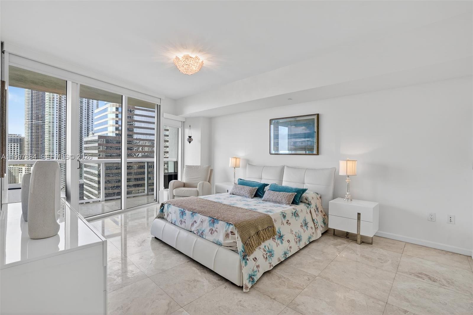 495 Brickell Avenue, Unit 2807 Miami, FL 33131 - Photo 13 of 23 a bedroom with a large bed and a lamp next to a window