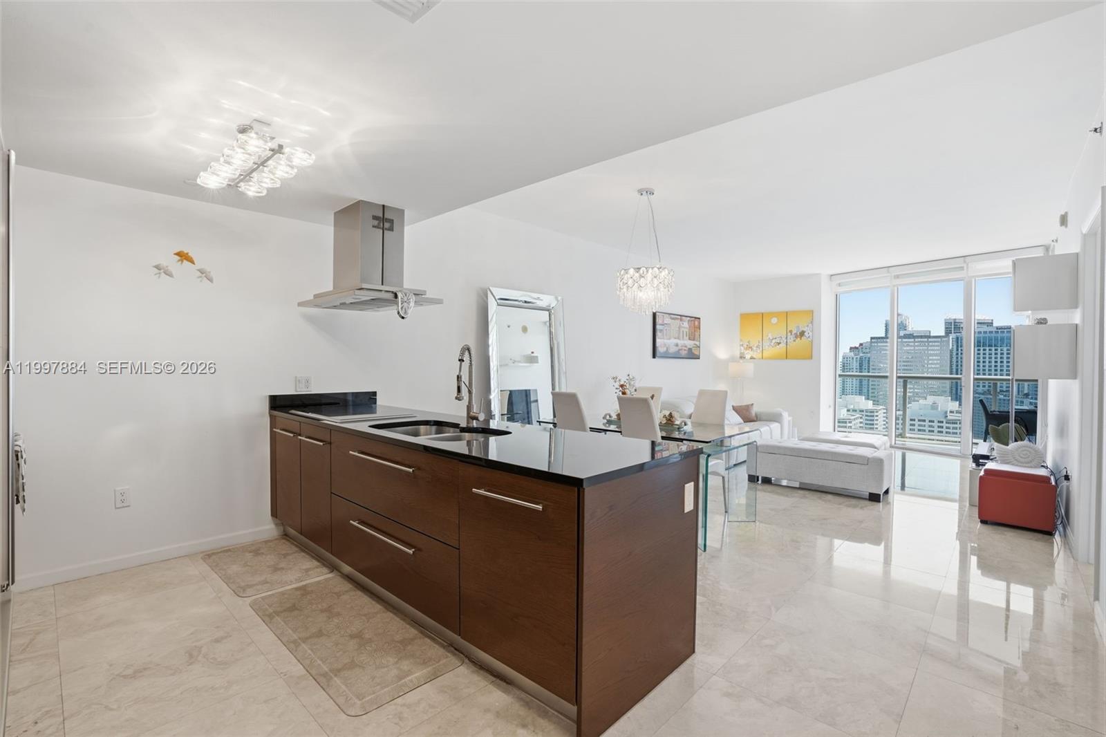 495 Brickell Avenue, Unit 2807 Miami, FL 33131 - Photo 5 of 23 a living room with furniture a chandelier and a view of kitchen