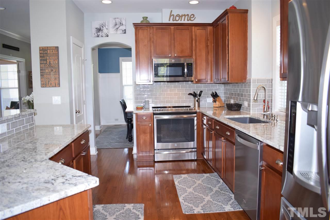 10108 2nd Star Court Raleigh, NC 27613 - Photo 5 of 23 Updated kitchen with granite counters, subway tile backsplash, breakfast bar, ss appliances, microbial sink & recessed lighting.
