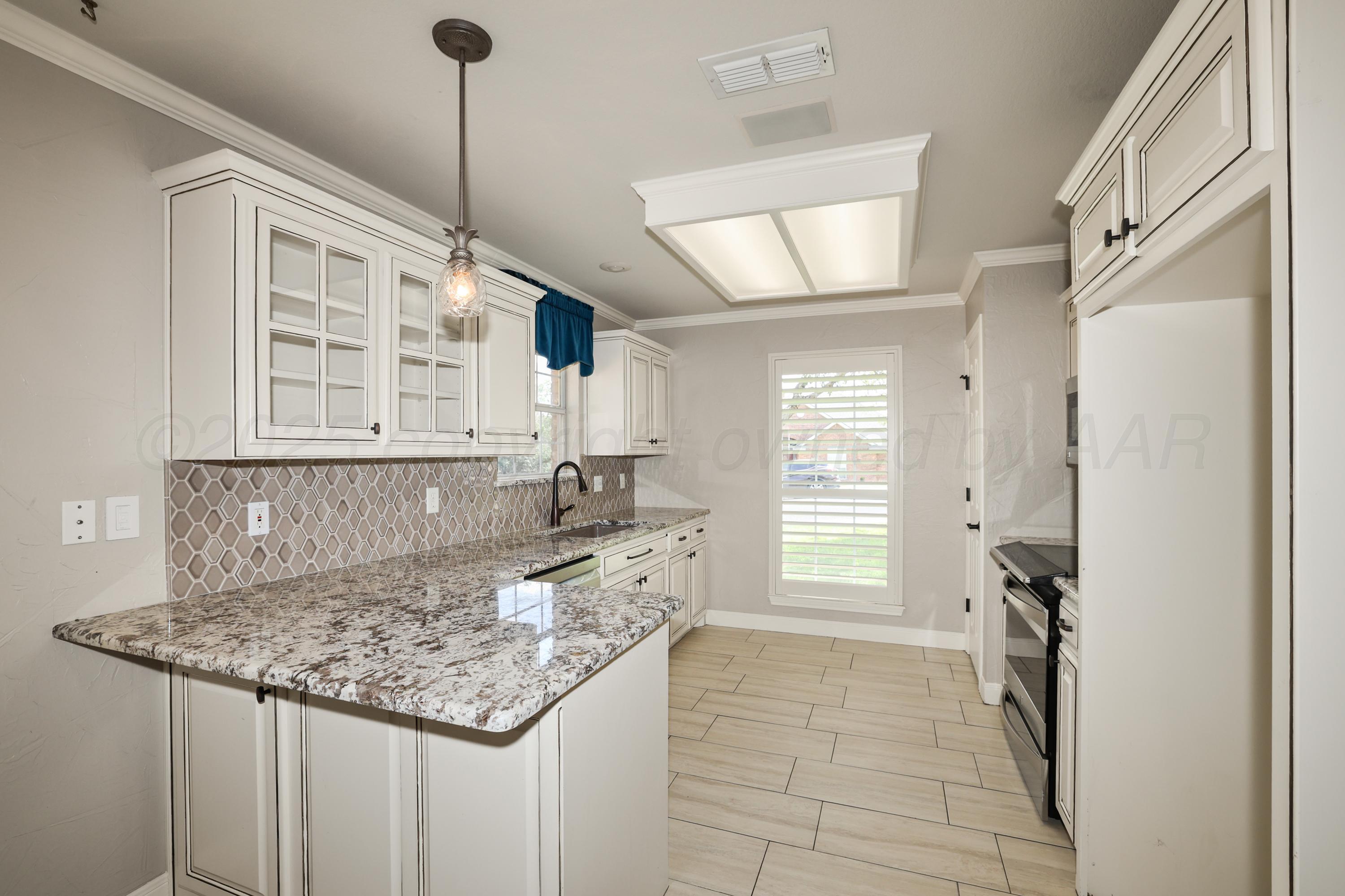 6506 Bayberry Lane Amarillo, TX 79124 - Photo 11 of 32 a kitchen with a stove a sink and a refrigerator