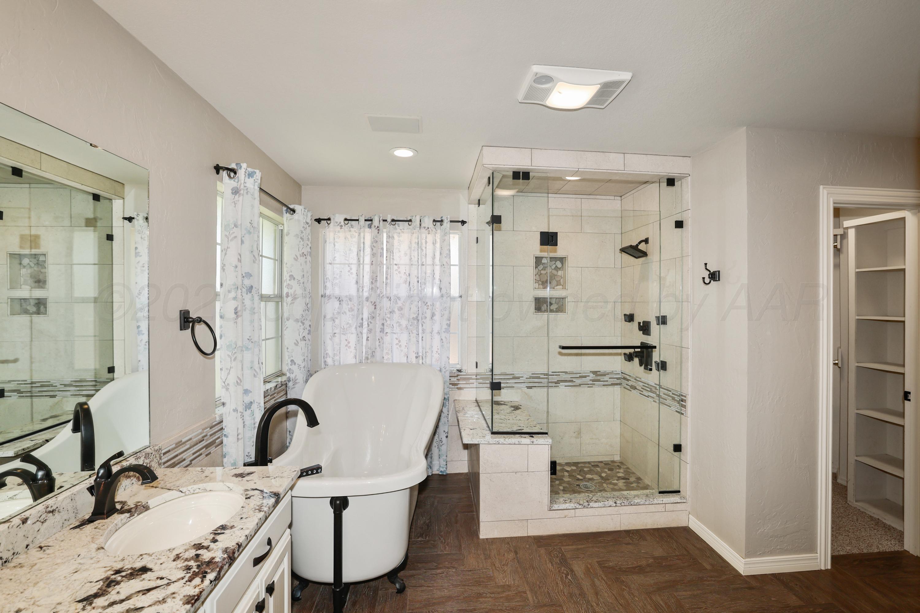6506 Bayberry Lane Amarillo, TX 79124 - Photo 19 of 32 a bathroom with a granite countertop sink a mirror and shower