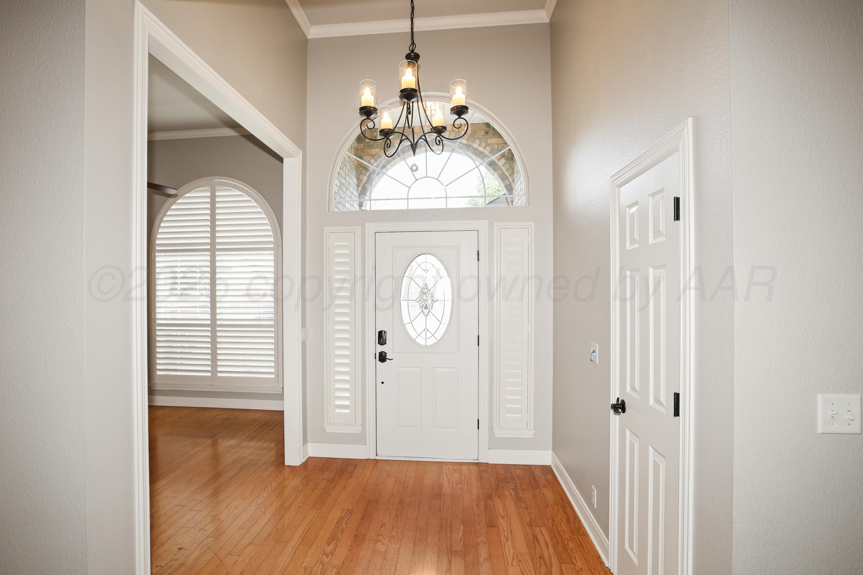 6506 Bayberry Lane Amarillo, TX 79124 - Photo 2 of 32 a view of a hallway with wooden floor and a chandelier