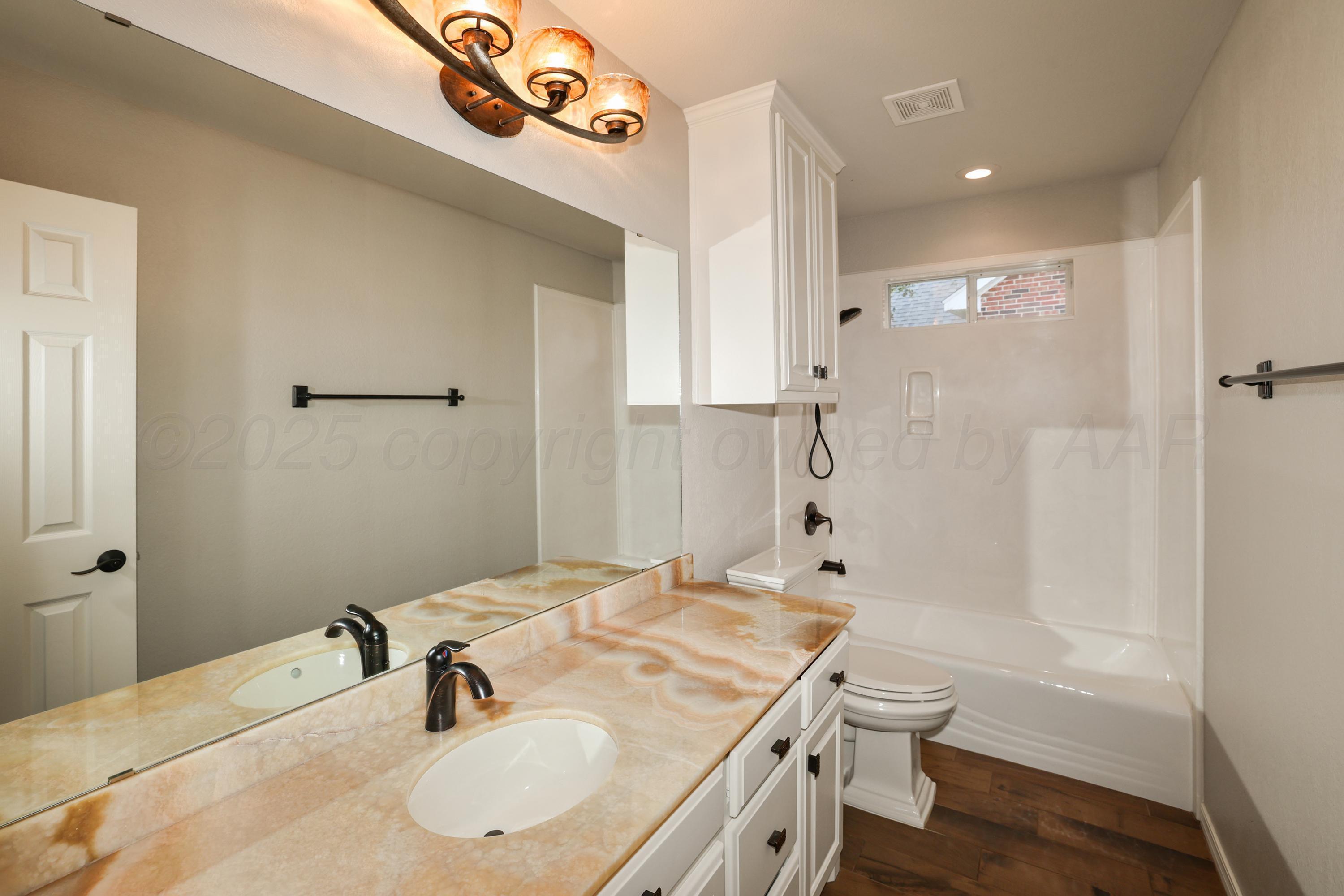 6506 Bayberry Lane Amarillo, TX 79124 - Photo 26 of 32 a bathroom with a sink a toilet and shower
