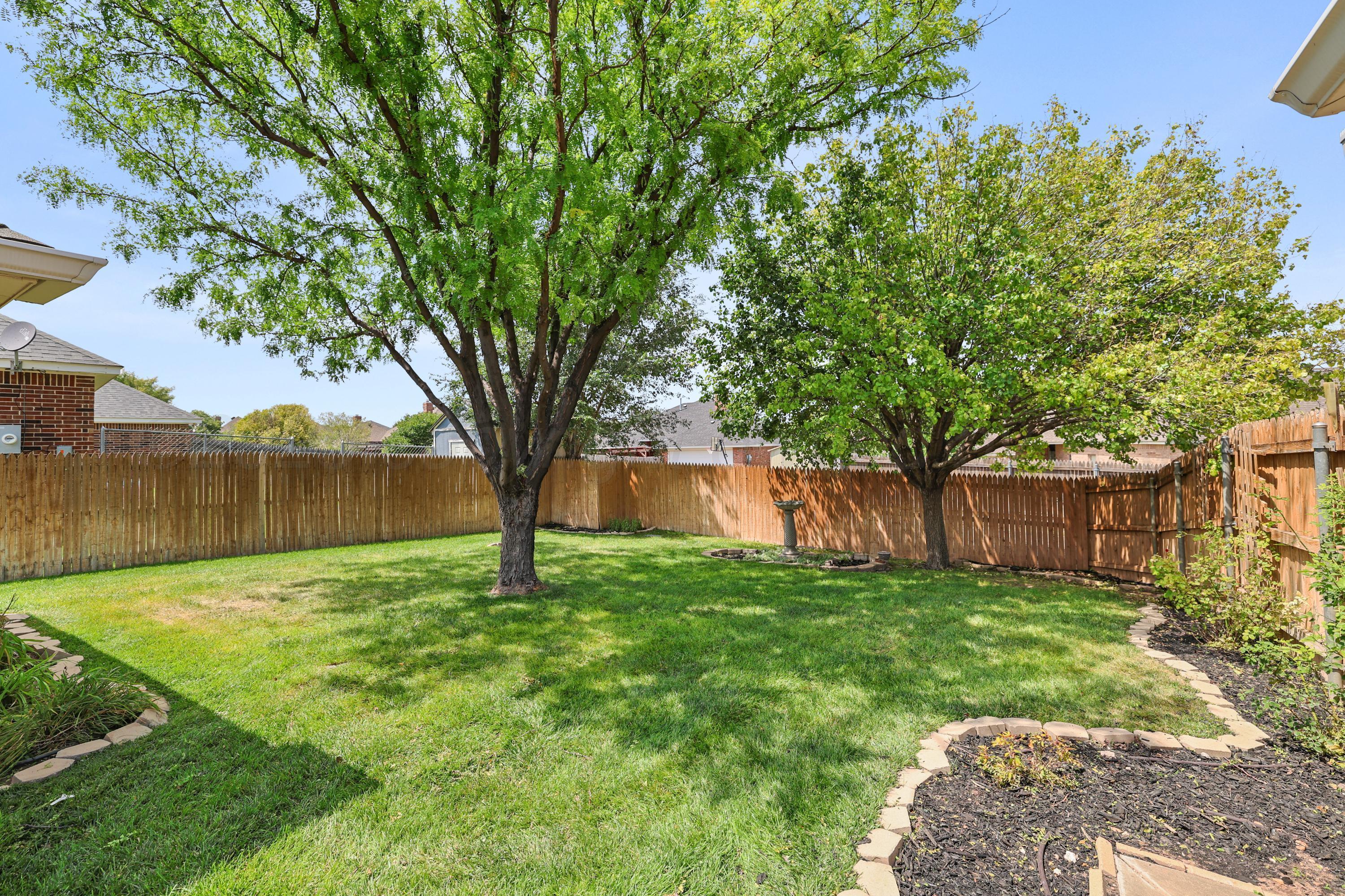 6506 Bayberry Lane Amarillo, TX 79124 - Photo 30 of 32 a big yard with large trees and wooden fence