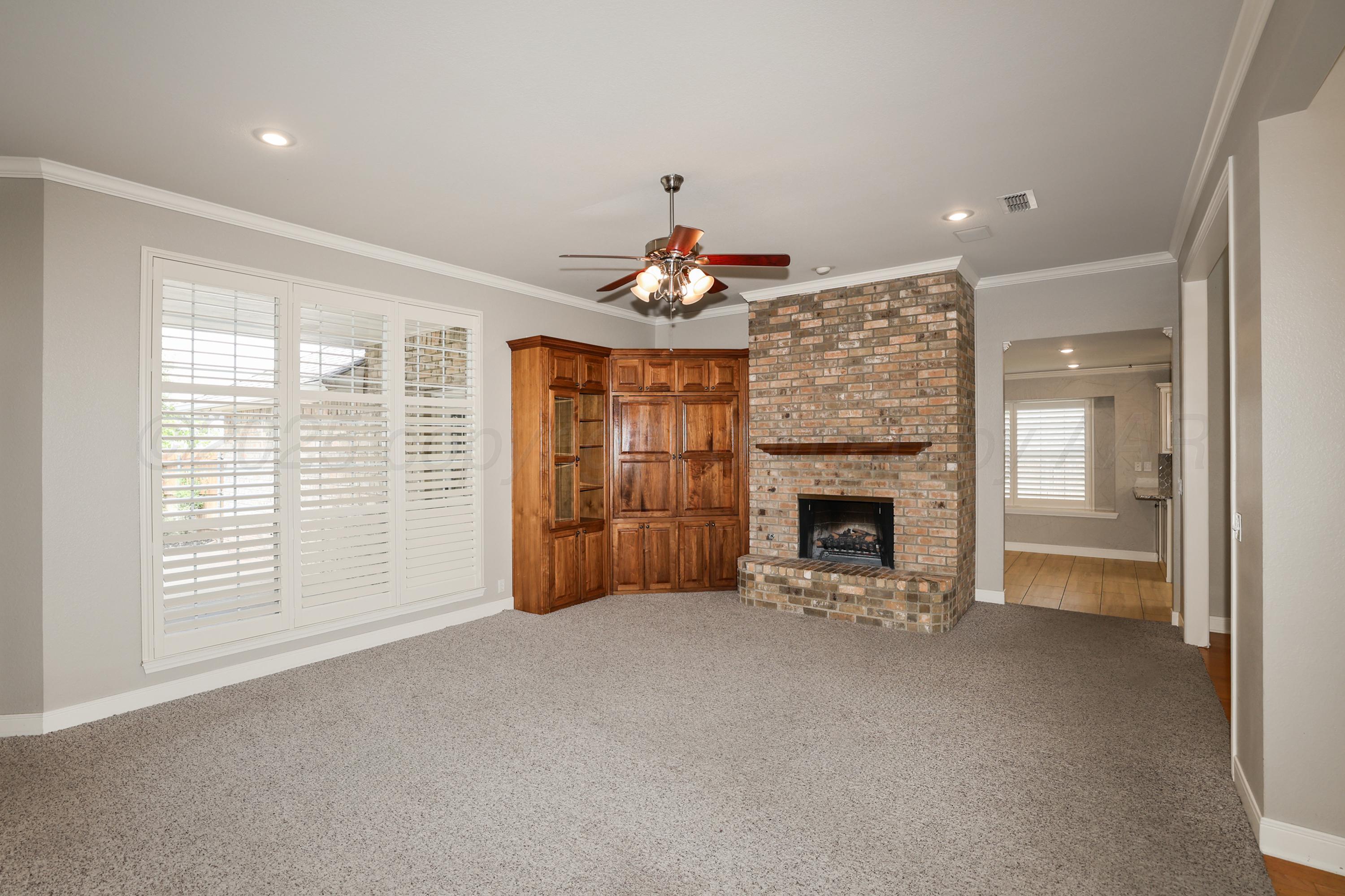 6506 Bayberry Lane Amarillo, TX 79124 - Photo 4 of 32 a view of an empty room with a fireplace and a window