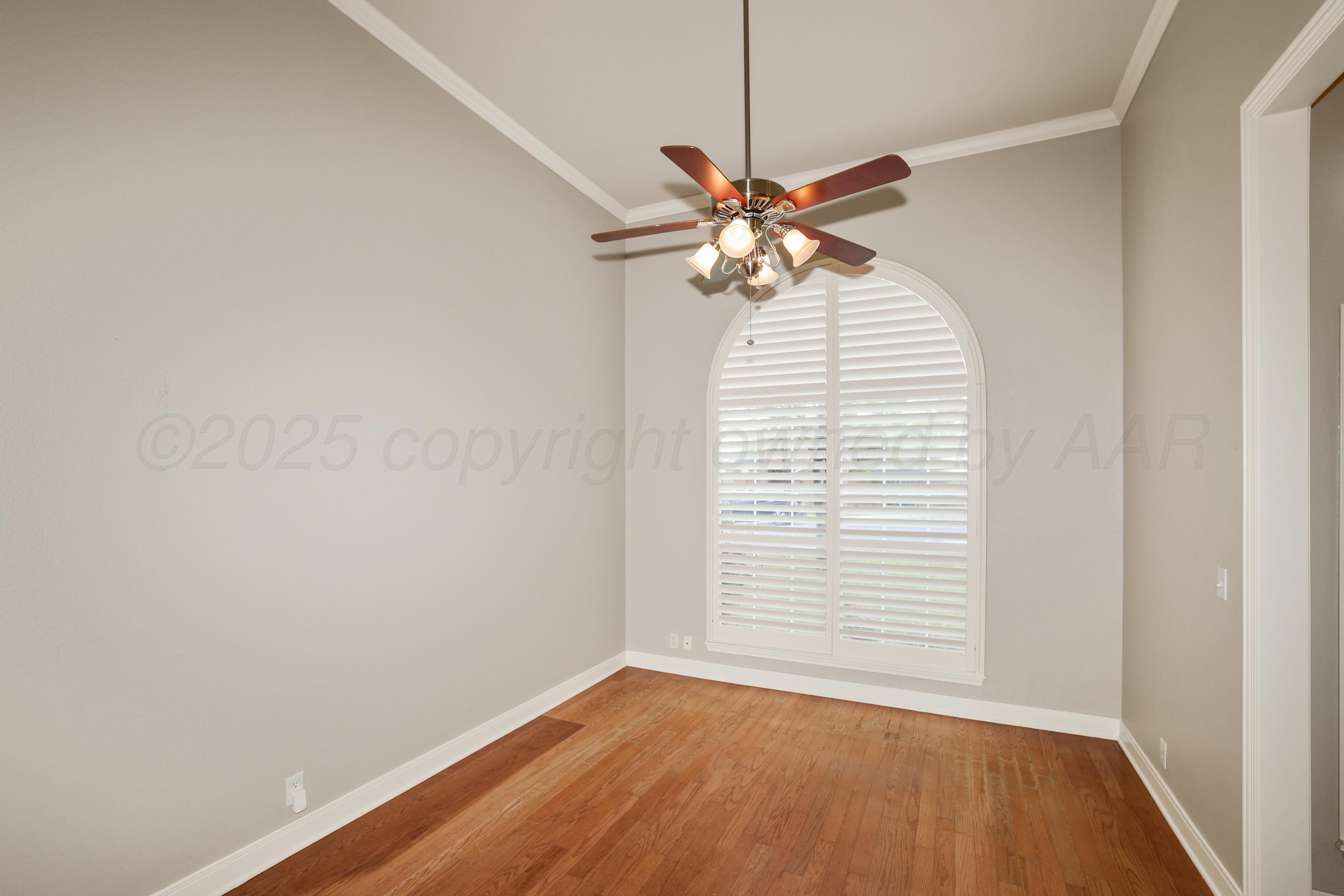6506 Bayberry Lane Amarillo, TX 79124 - Photo 7 of 32 an empty room with a window and wooden floor