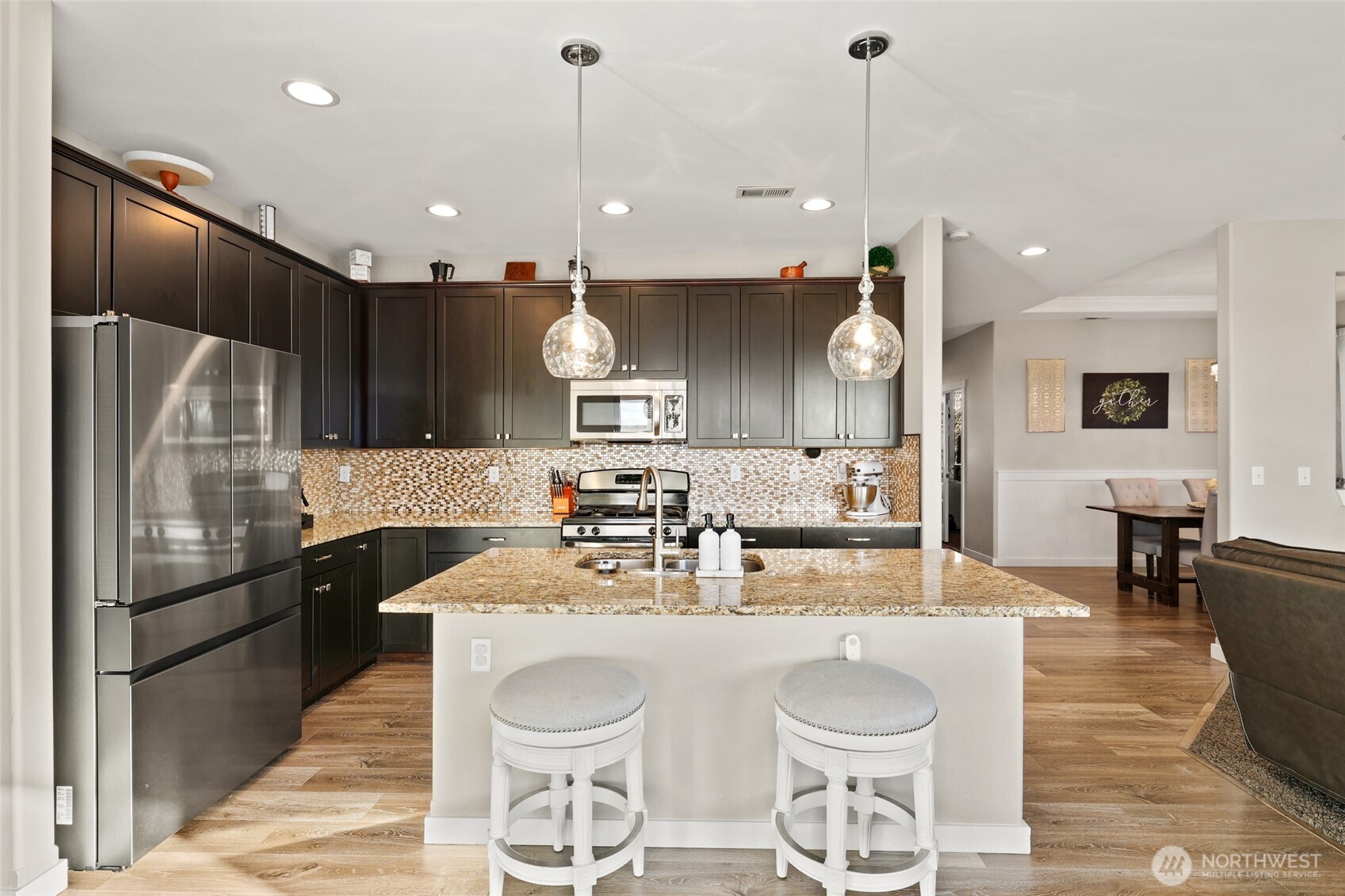 1320 34th Street Southeast Puyallup, WA 98372 - Photo 12 of 40 a kitchen with stainless steel appliances granite countertop a sink a stove a refrigerator cabinets and chairs