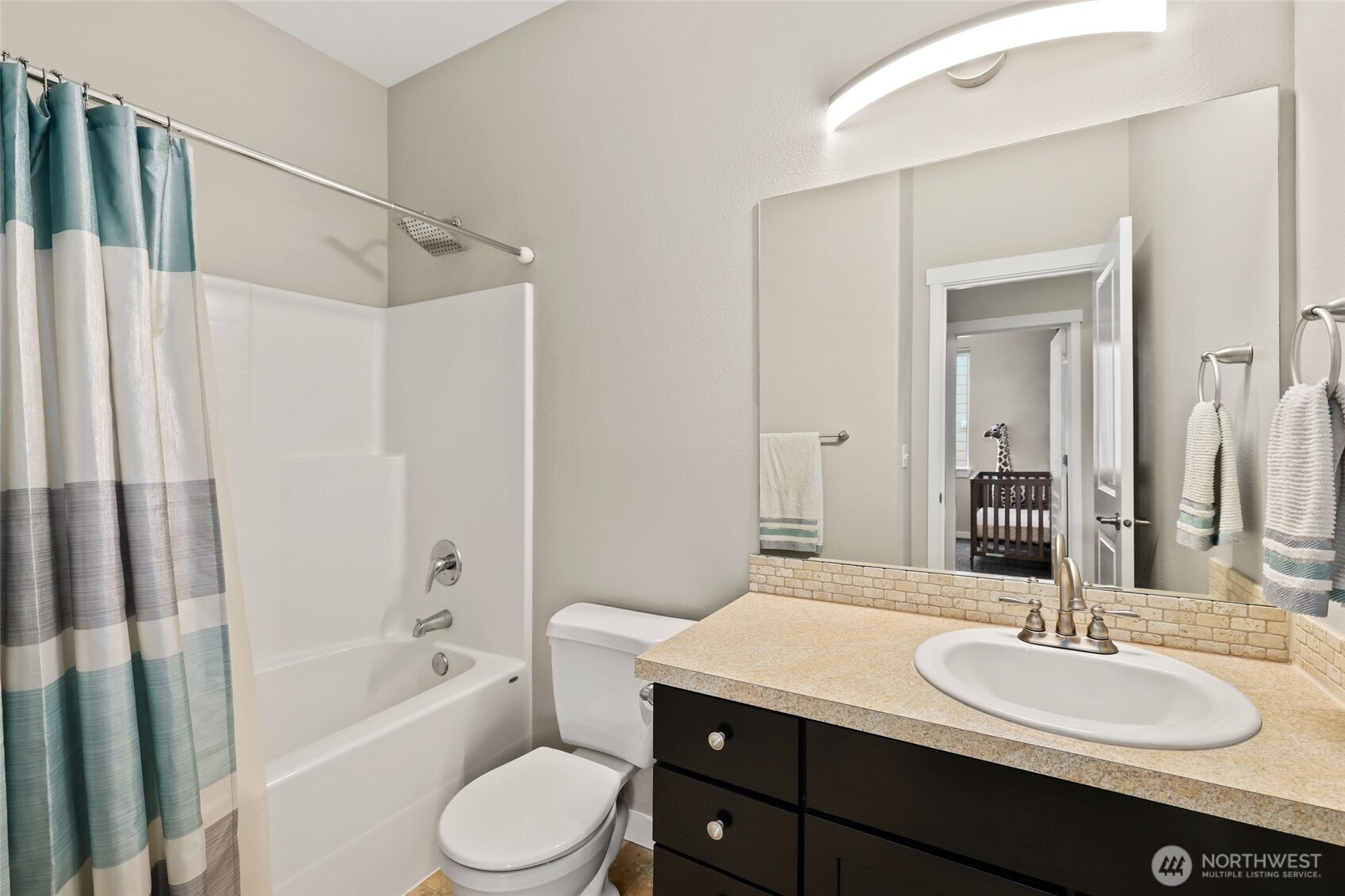 1320 34th Street Southeast Puyallup, WA 98372 - Photo 27 of 40 a bathroom with a granite countertop sink toilet a mirror a bathtub and shower