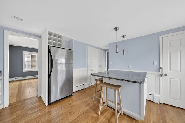 a kitchen with granite countertop a refrigerator and a stove top oven