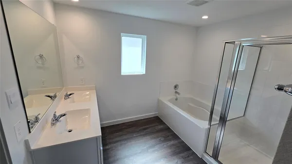a bathroom with a tub sink and mirror