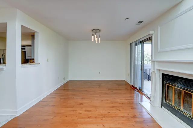 a view of empty room with wooden floor and fireplace