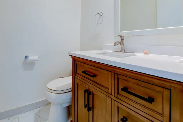 a bathroom with a sink a toilet and a mirror