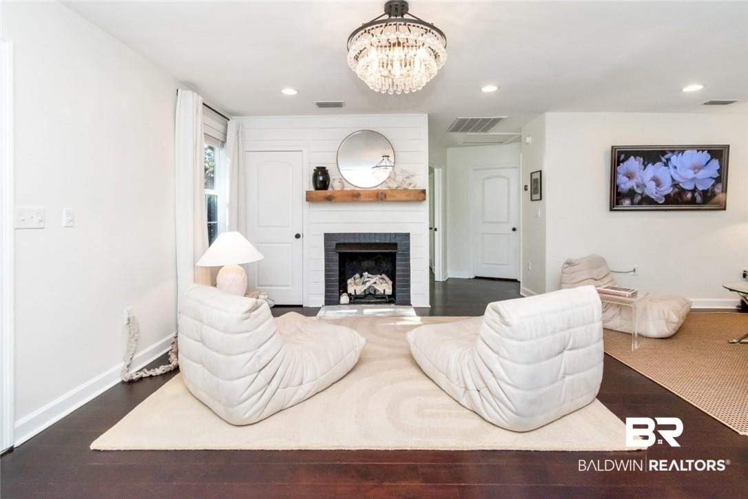 5200 Border Drive South Mobile, AL 36608 - Photo 2 of 26 Living room featuring a fireplace, dark hardwood / wood-style floors, and a notable chandelier