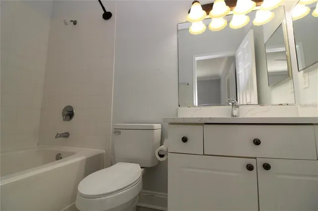 a bathroom with a granite countertop sink a toilet and a mirror