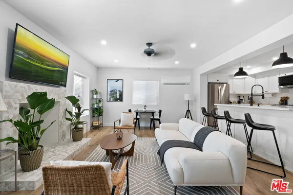 a living room with lots of furniture and view of kitchen