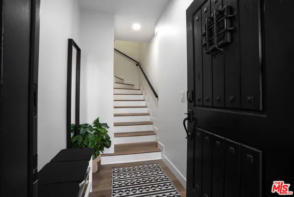 a view of a hallway with wooden floor and a potted plant