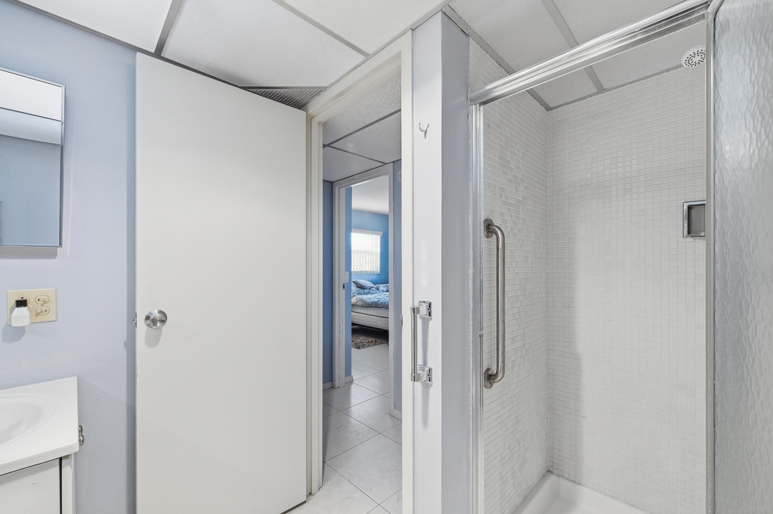 669 Saxony Place Delray Beach, FL 33446 - Photo 24 of 34 a bathroom with a glass shower door