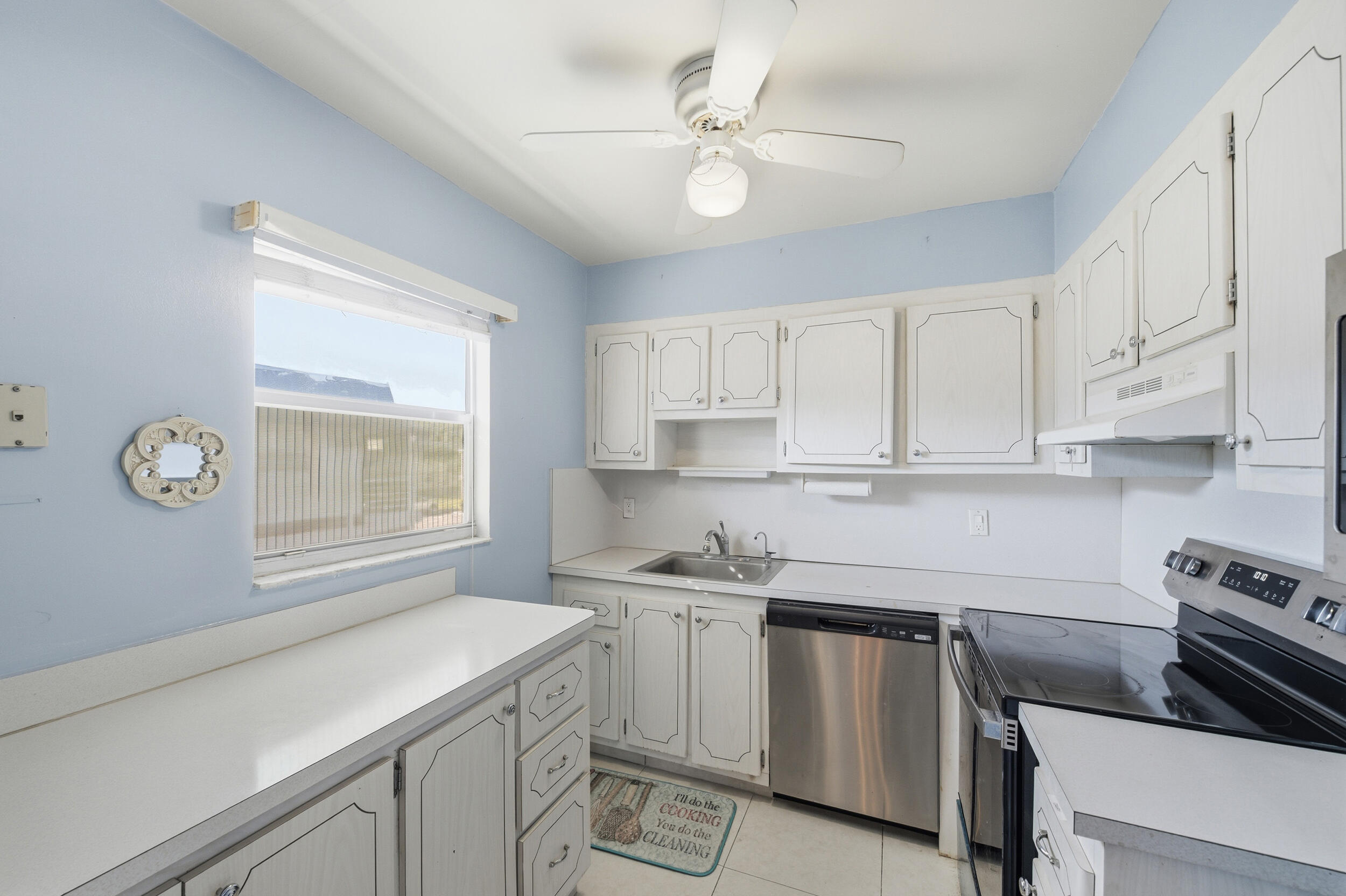 669 Saxony Place Delray Beach, FL 33446 - Photo 29 of 34 a kitchen with a sink cabinets stainless steel appliances and a window