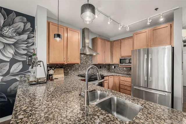 a kitchen with stainless steel appliances granite countertop a sink refrigerator and cabinets