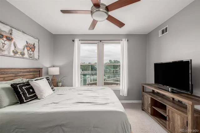a bedroom with a bed and a flat tv screen on the dresser