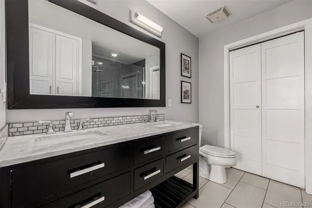a bathroom with a granite countertop sink a toilet and a mirror