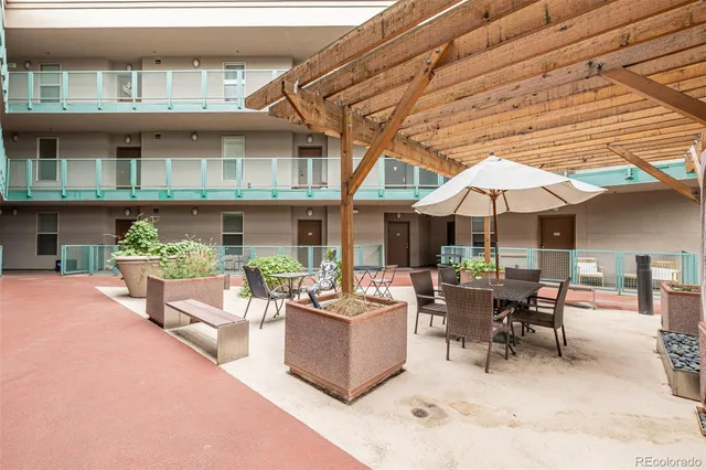 a view of a patio with couches and table and chairs under an umbrella
