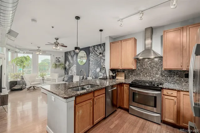 a kitchen with stainless steel appliances granite countertop a sink stove and refrigerator
