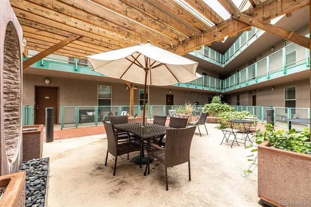 a view of a patio with table and chairs under an umbrella