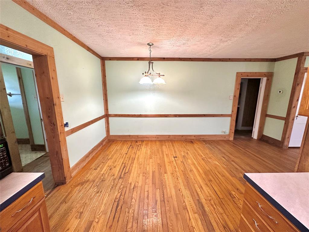 1694 Old Luling Road Lockhart, TX 78644 - Photo 12 of 20 Unfurnished dining area with light wood finished floors and a textured ceiling