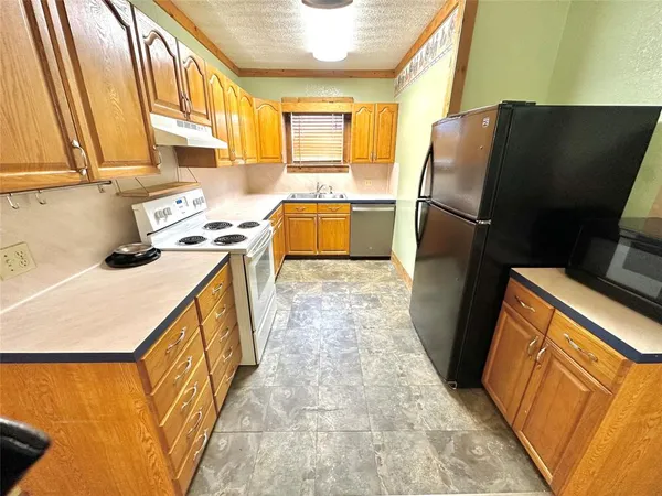a kitchen with stainless steel appliances a refrigerator sink and stove