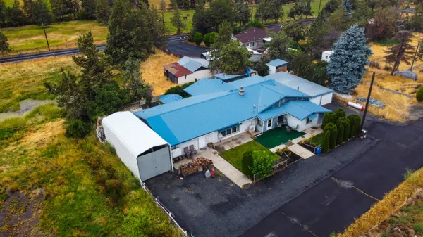 an aerial view of a house with a yard swimming pool and outdoor seating