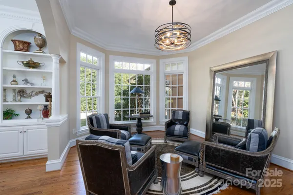 a living room with furniture a chandelier and a large window