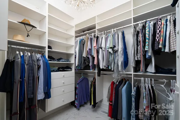 a view of walk in closet with clothes
