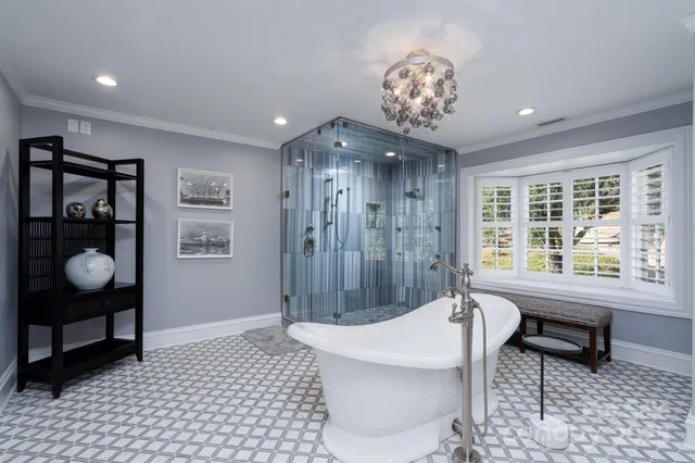 a spacious bedroom with a large bed and a chandelier