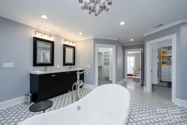 a spacious bathroom with a double vanity sink a mirror and a bathtub