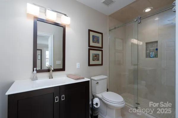 a bathroom with a double vanity sink toilet and a mirror