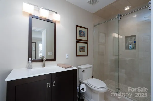 a bathroom with a double vanity sink toilet and a mirror