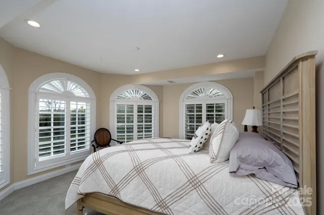 a bed sitting in a bedroom next to a large window