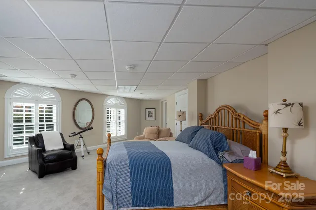 a bed room with a bed a mirror and lamp