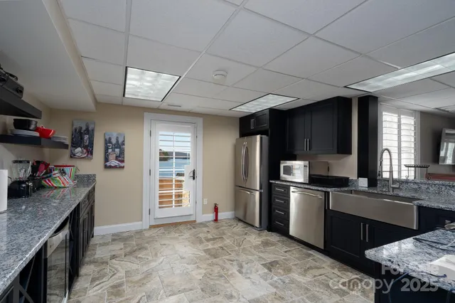 a kitchen with stainless steel appliances granite countertop a sink stove and refrigerator