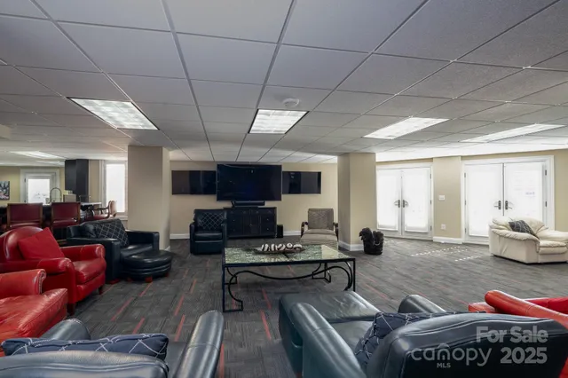 a living room with furniture a flat screen tv and kitchen view