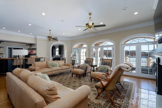 a living room with furniture two large windows and a chandelier