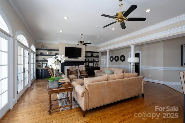 a living room with furniture and a flat screen tv with kitchen view