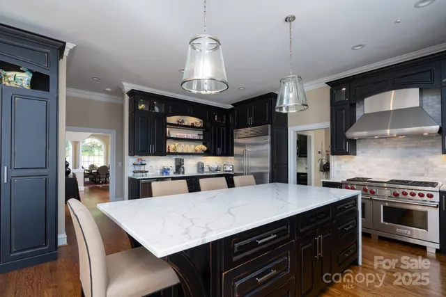 a kitchen with stainless steel appliances a stove a sink island and a refrigerator