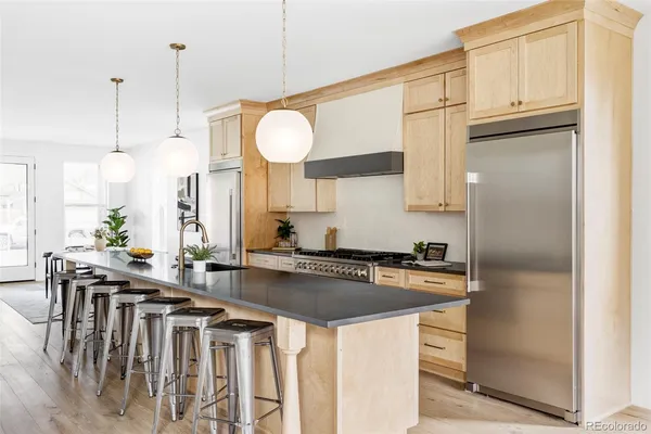 a kitchen with stainless steel appliances granite countertop a sink a stove and a refrigerator
