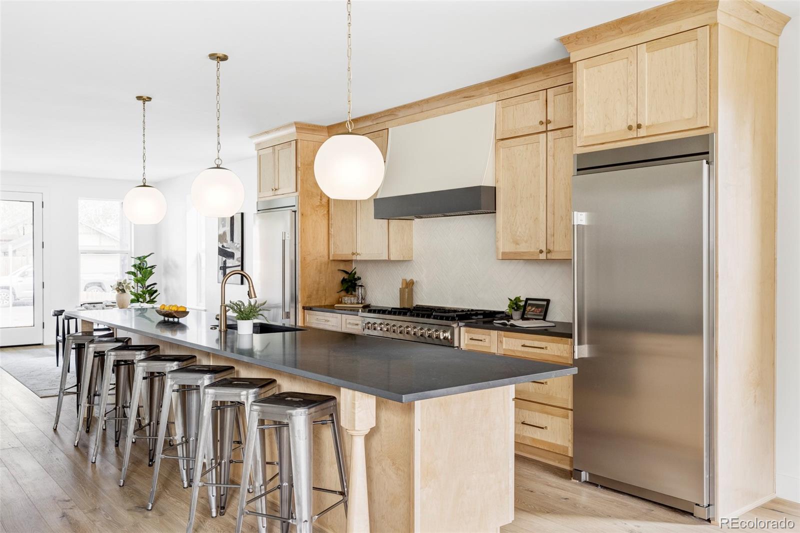 a kitchen with stainless steel appliances granite countertop a sink a stove and a refrigerator