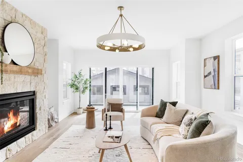 a living room with furniture a fireplace and a chandelier