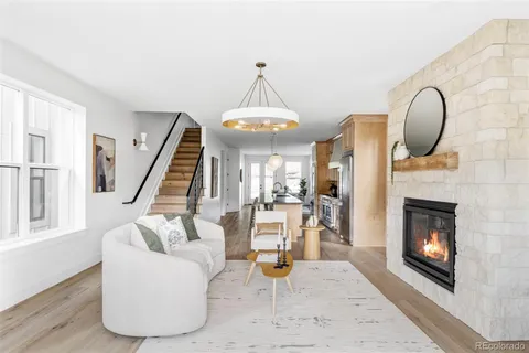 a living room with furniture a fireplace and a chandelier